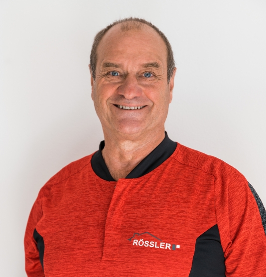Foto von Gerhard Rössler, lachend, im roten T-Shirt mit Firmenlogo