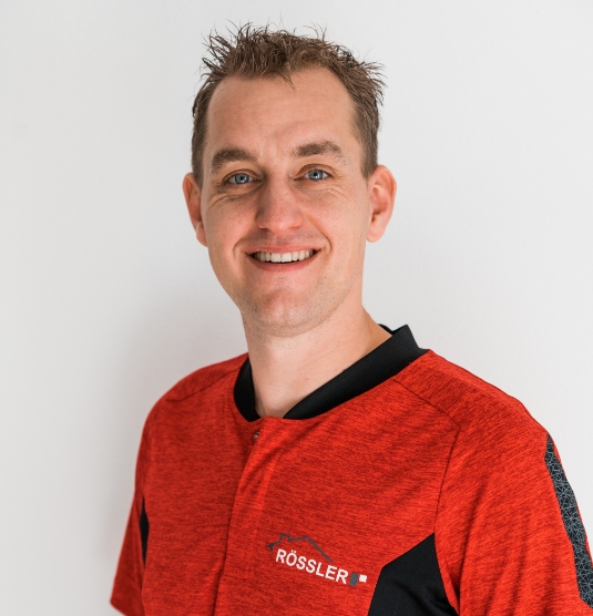 Foto von Markus Rössler, lachend, im roten T-Shirt mit Firmenlogo